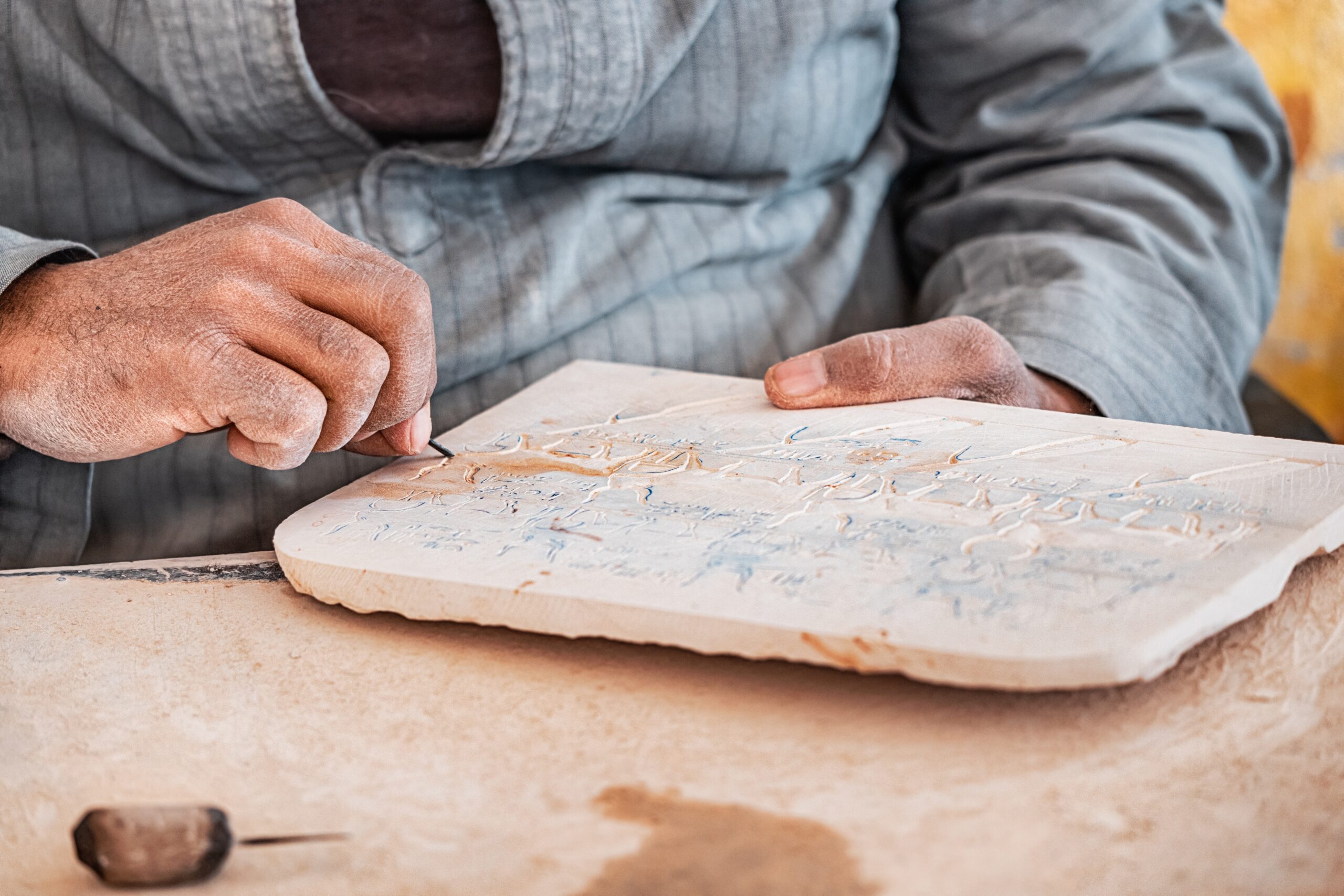 An,Artisan,Carves,Egyptian,Hieroglyphs,On,A,Stone,Tablet,For